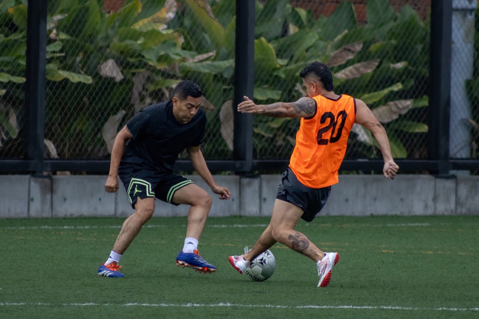 Dos jugadores adultos disputando un balón durante el entrenamiento