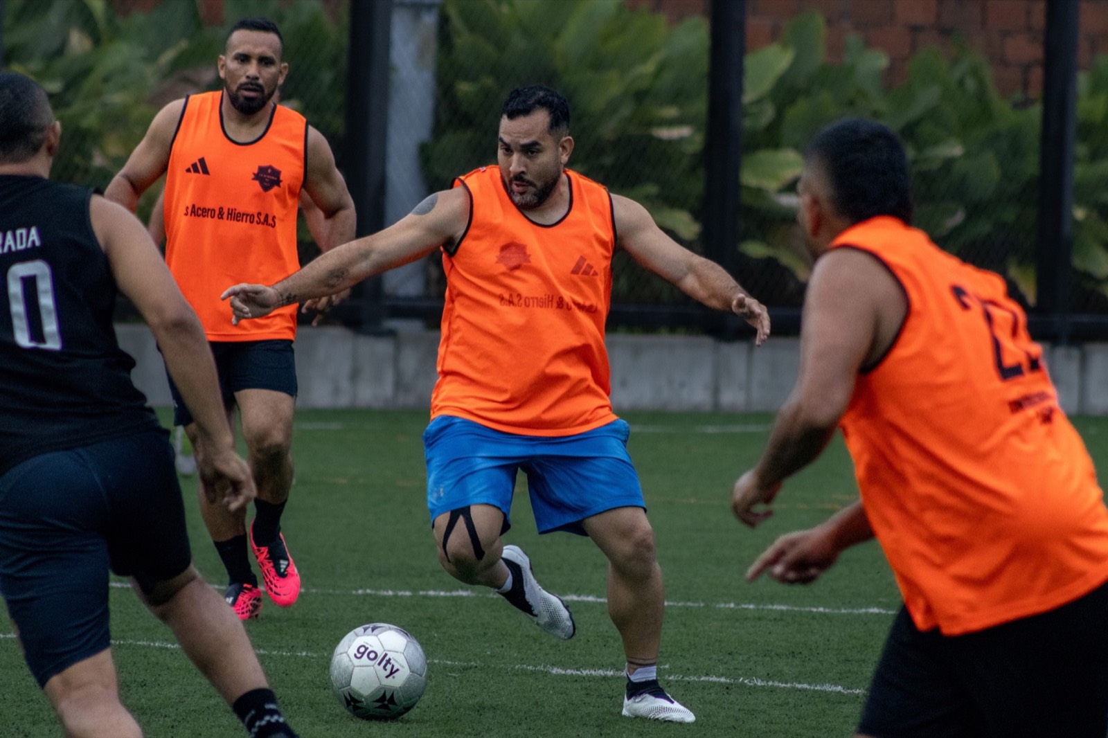 Jugadores adultos compitiendo por la posesión del balón