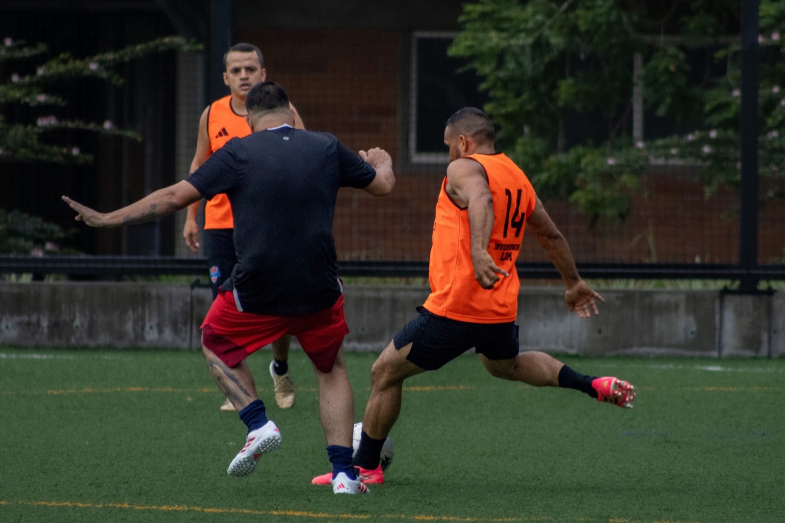 Jugador adulto conduciendo el balón mientras sus compañeros acompañan la jugada